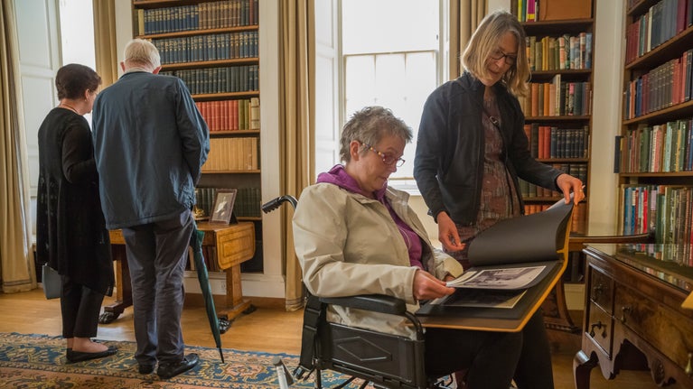 Two women look at books in the library at Upton House and Gardens in Warwickshire